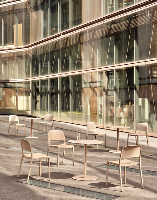 A set of modern furniture placed on the terrace in front of a glass office building
