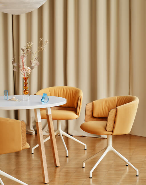 Modern honey-coloured Collar upholstered chairs at a round table in a bright interior