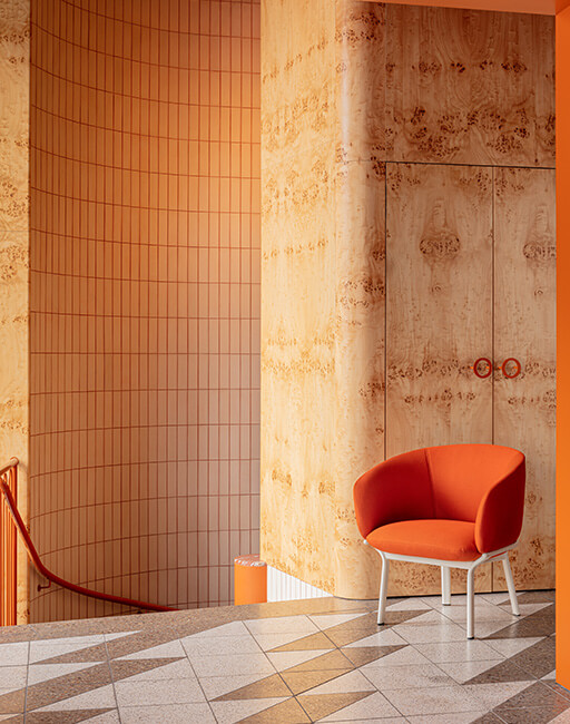 Orange armchair in a modern interior with wood wall panels, tiled wall and geometric floor