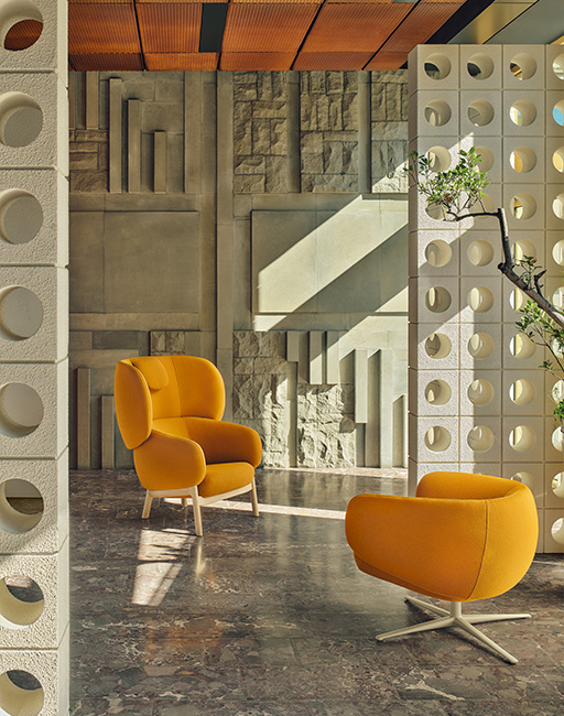Two soft yellow seats in a designer interior with concrete walls and decorative fittings