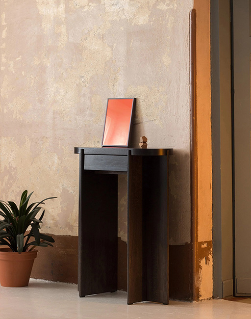 Wooden chest of drawers on metal legs with a slatted front, placed by the window