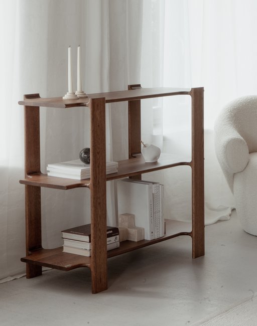 Ligo wooden bookcase with three shelves, books and candlesticks in a bright interior