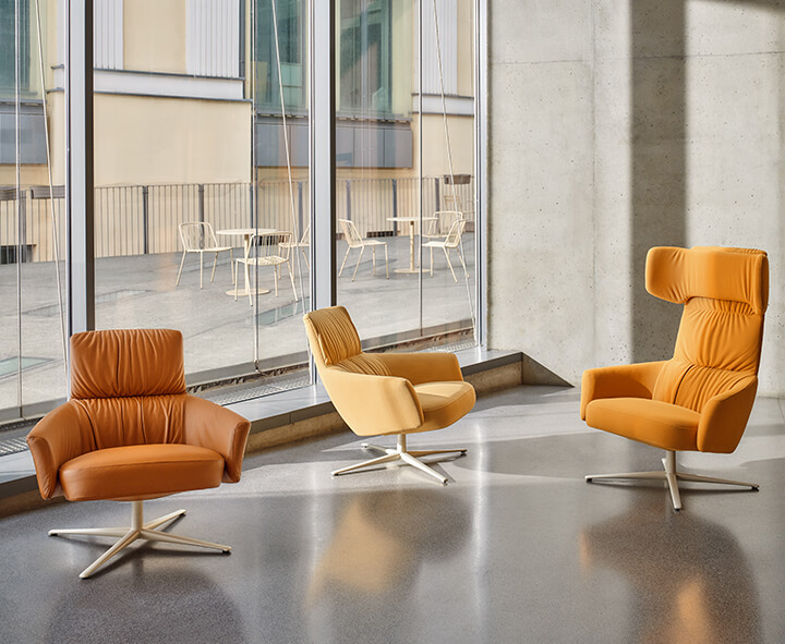 A modern coworking space furnished with office furniture, bookcases and colourful poufs.