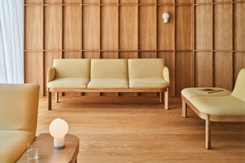 Three-seater sofa with beige upholstery and visible wooden frame